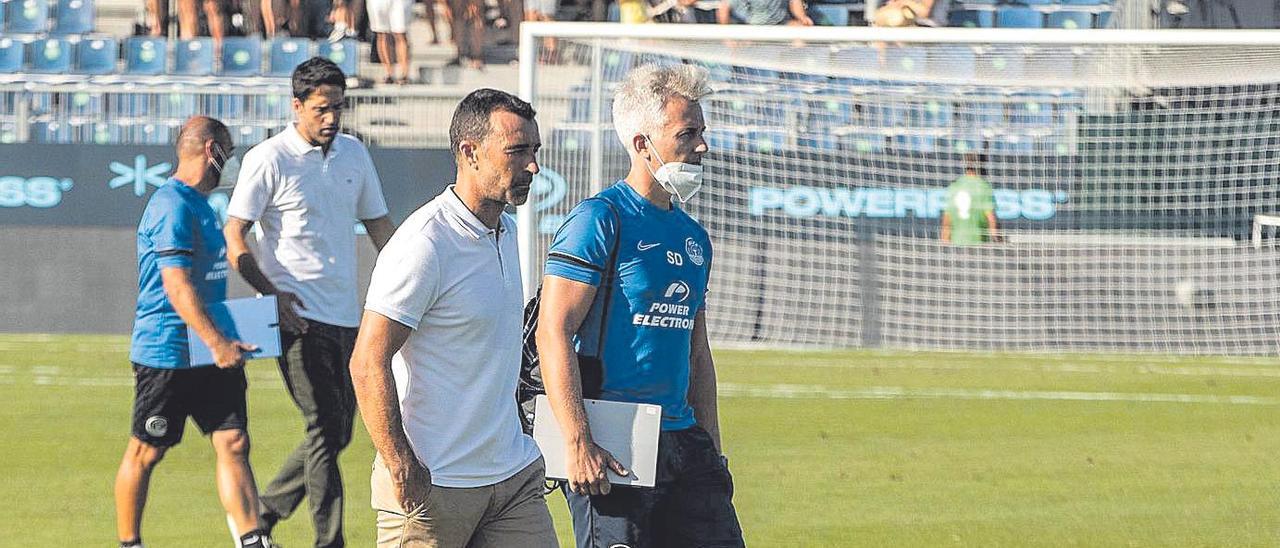 Carcedo junto a su preparador físico sobre el césped.