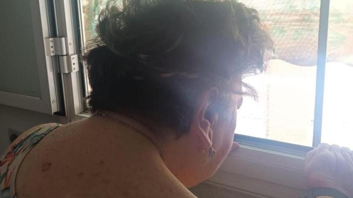 Teresa se asoma a la ventana de su casa.