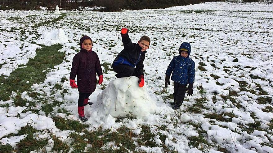 Tres niños juegan con la nieve en Xestoso.