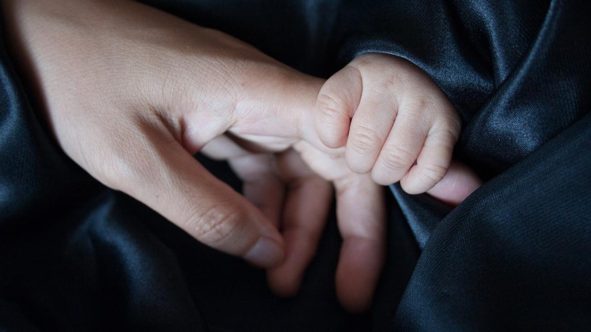 La mano de un padre y la de su bebé.