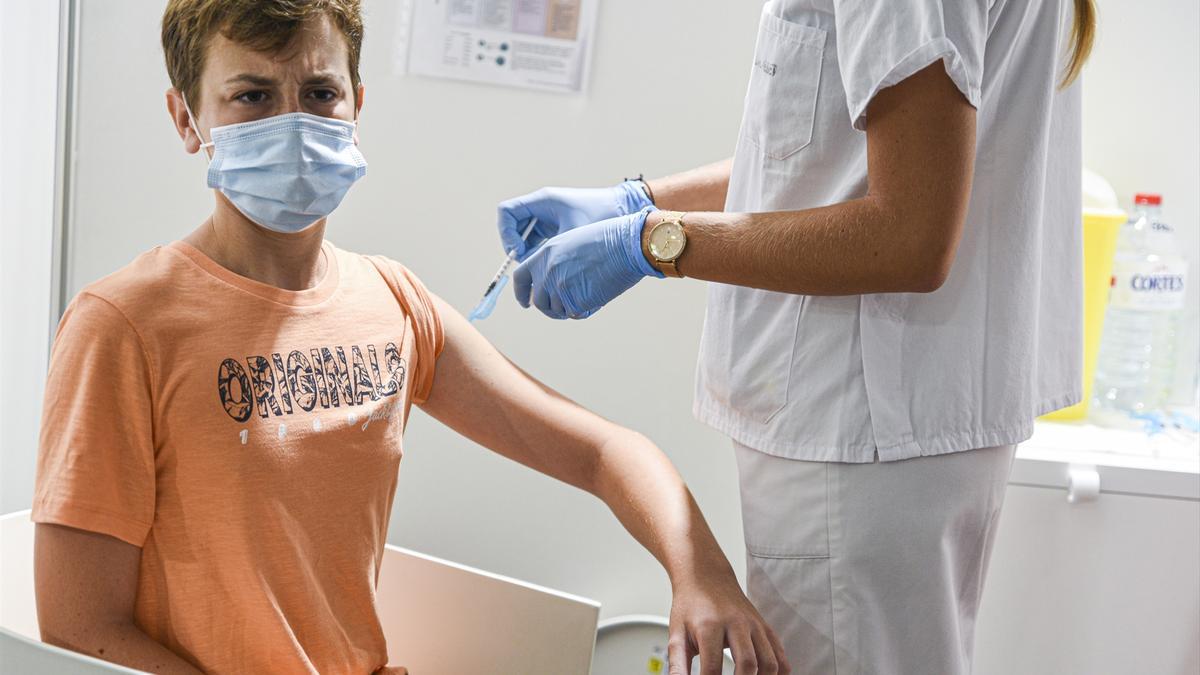 Una sanitaria vacuna a un adolescente