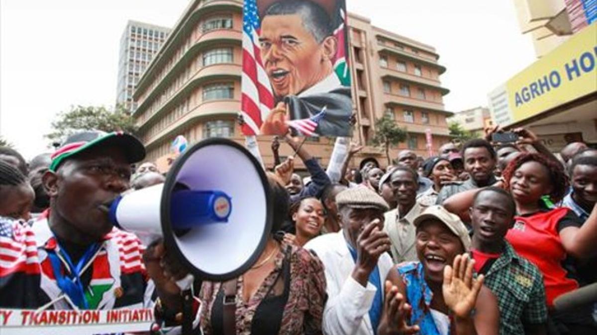 Simpatizantes de Obama vitorean al presidente de EEUU mientras esperan verle pasar, en Nairobi, ayer.