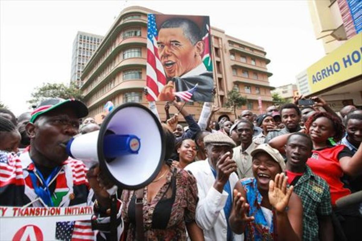 Simpatizantes de Obama vitorean al presidente de EEUU mientras esperan verle pasar, en Nairobi, ayer.
