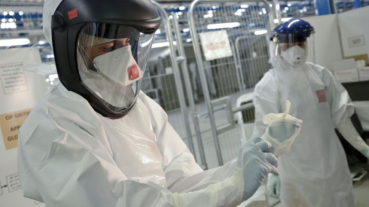 Chris Paterson muestra a los médicos del NHS cómo ponerse el equipo de protección personal (PPE) que usarán en los centros de tratamiento del ébola construidos por Gran Bretaña en Sierre Leone.