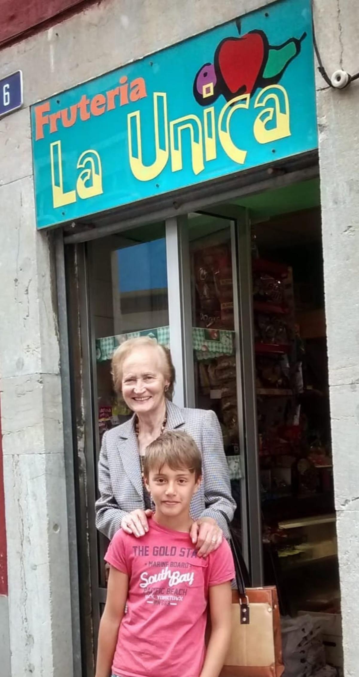 Una foto de archivo de Trinidad Gómez en la puerta de su negocio con su nieto Hugo Cosano.