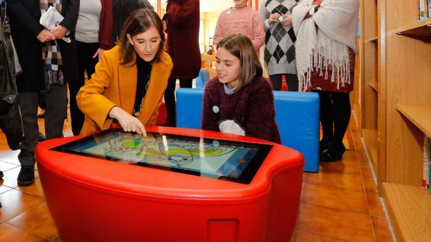 La conselleira Carmen Pomar prueba junto a una alumna la mesa interactiva de una de las salas. // C.E.