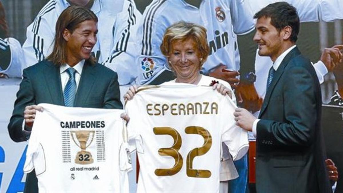 Esperanza Aguirre, madridista confesa, celebra exultante el reciente título de Liga conseguido por el Real Madrid, flanqueada por Sergio Ramos e Iker Casillas.