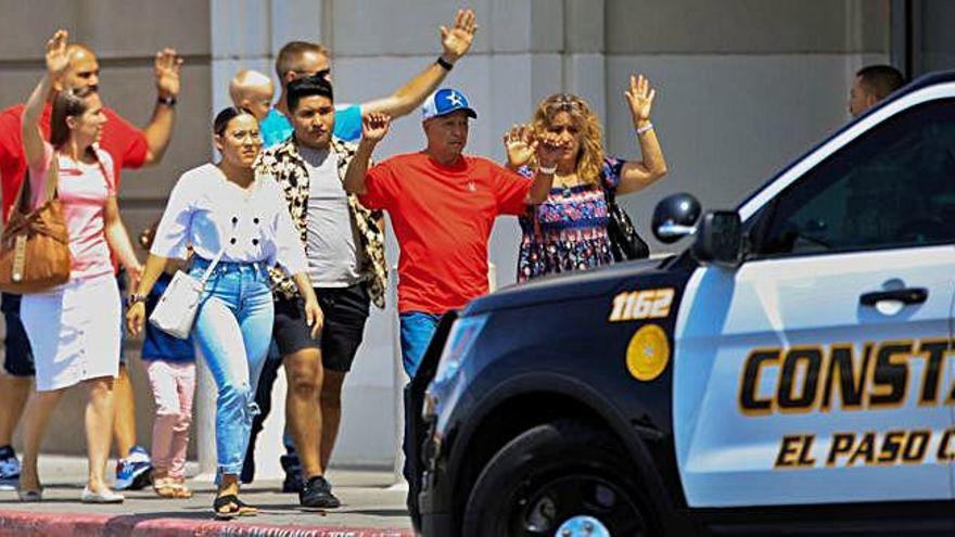 Un grup de persones abandona el centre comercial sota la protecció de la Policia Local