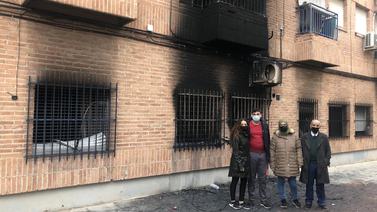 El matrimonio y dos de sus hijos, en la puerta de la casa calcinada en Barriomar.