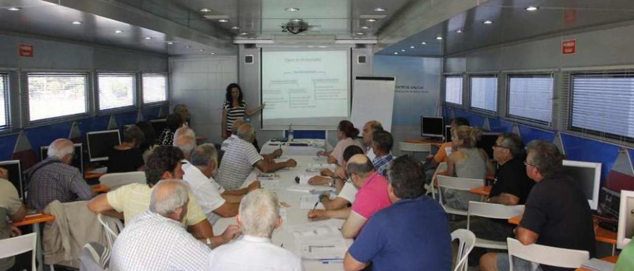 Arriba, alumnos en el aula móvil de la Consellería de Medio Rural. Abajo, el autobús con el aula estacionado en Reibón. // G.N.