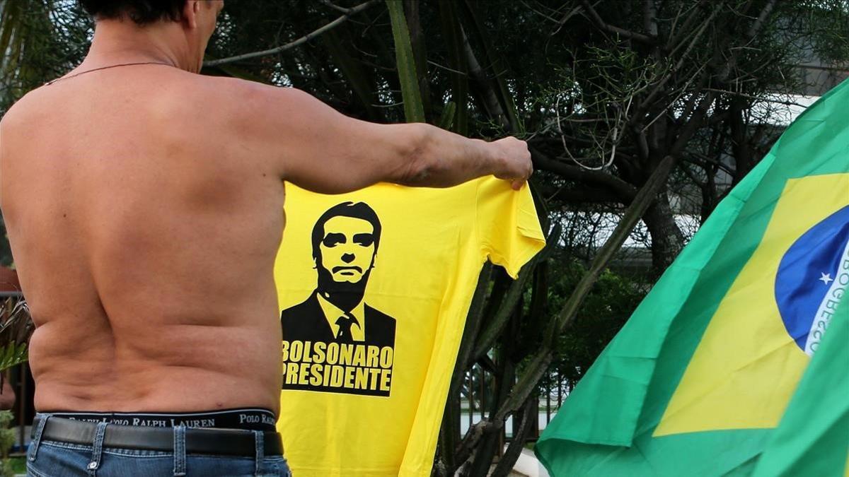 Un partidario de Bolsonaro enseña una camiseta con su cara en Rio de Janeiro