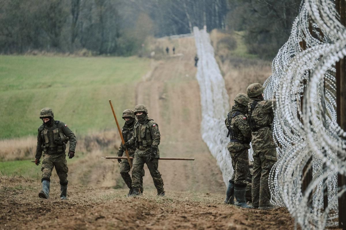 Soldados del ejército polaco arreglan bobinas de alambre de púas en una valla a lo largo de la frontera polaca, con el enclave ruso de Kaliningrado, cerca de Zerdziny, Polonia