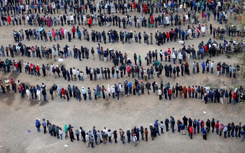 La gente hace cola fuera de una mesa electoral para emitir su voto durante las elecciones presidenciales en el centro de la ciudad en Nairobi, Kenia,