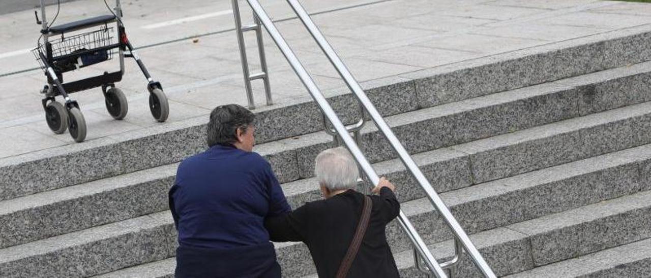 Una cuidadora ayuda
a una mujer a subir
unas escaleras.
  // X. Álvarez