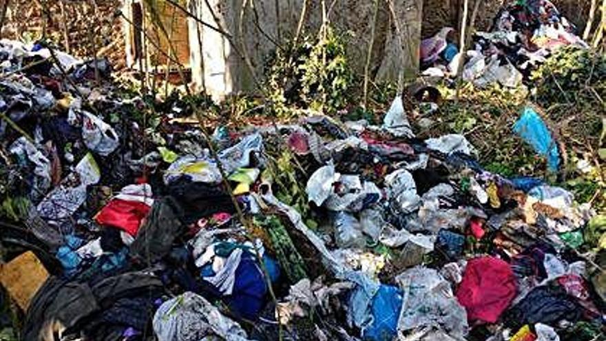 L&#039;amo de la finca amb muntanyes de roba abandonades les treu amb una excavadora