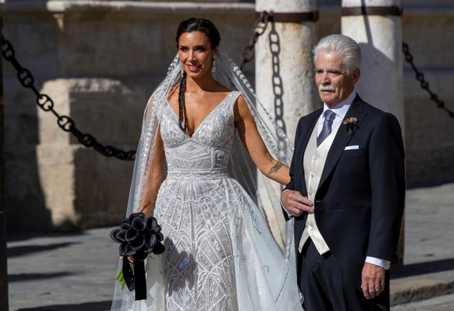 La presentadora Pilar Rubio, junto a su padre, a su llegada a la Catedral de Sevilla donde se celebra este sábado su boda con el futbolista Sergio Ramos.