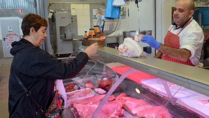 Inmaculada Millán compra carne en la tienda de José Manuel Limeres, ayer. // Noé Parga