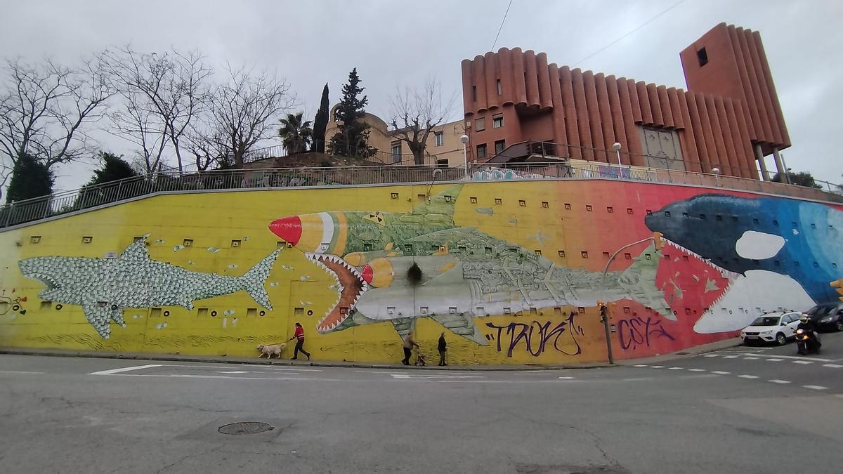 El mural de los tiburones del Carmel, manchado por dos grandes 'tags' debajo del escualo que representa a la guerra, en Barcelona.