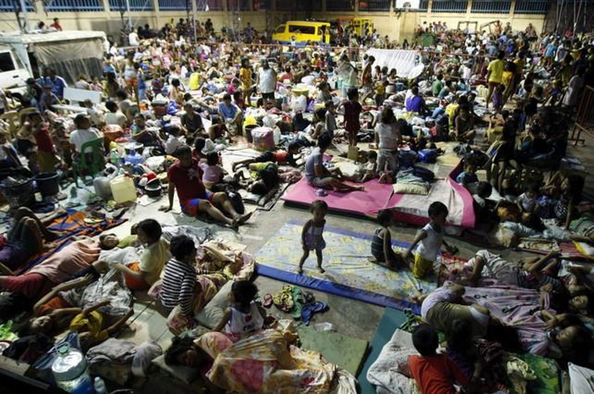 Centenars de persones s’amunteguen en un pavelló esportiu a la localitat de Mambaling, província de Cebu.