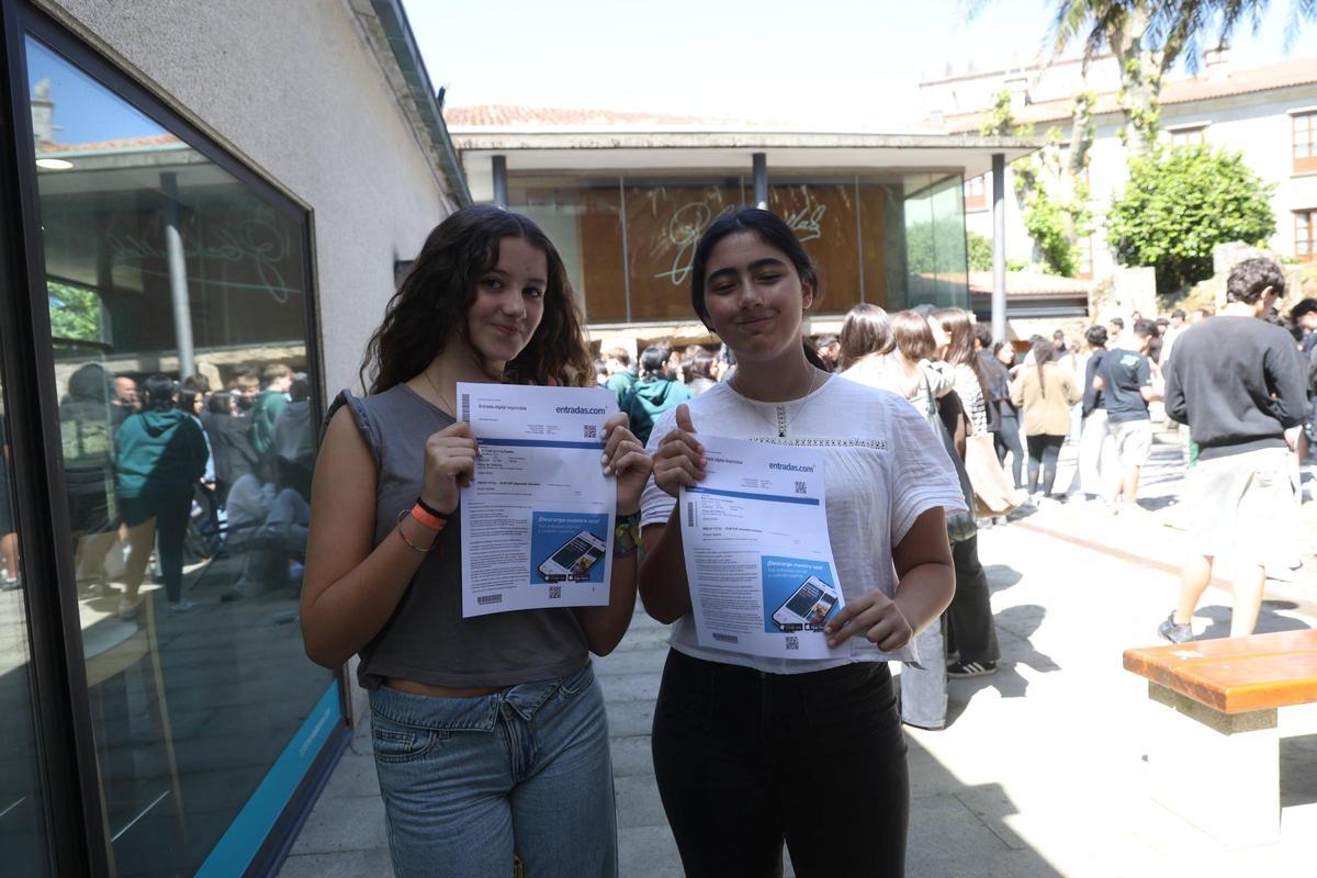Dos jóvenes muestran sus entradas ante la oficina de Turismo.