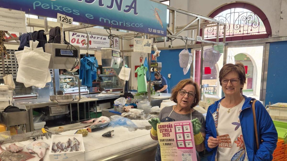 Juana, da peixería da praza, fai entrega da tarxeta regalo a María, familia do premiado José Luis Bouzas.