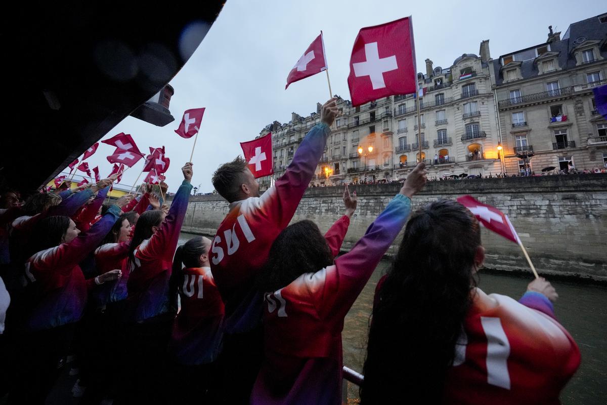 Miembros del Equipo de Suiza saludan a los espectadores en París, Francia, durante la ceremonia de apertura de los Juegos Olímpicos