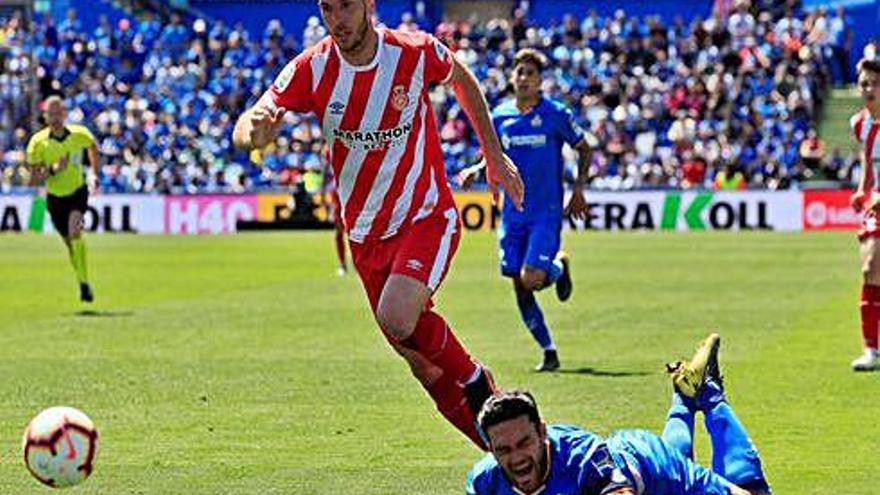 Alcalá persegueix una pilota amb Jorge Molina a terra.