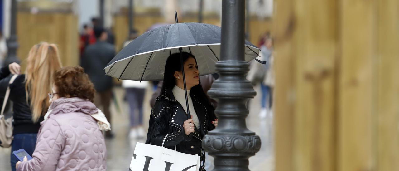 Gente pasea bajo la lluvia por el Centro de Málaga.