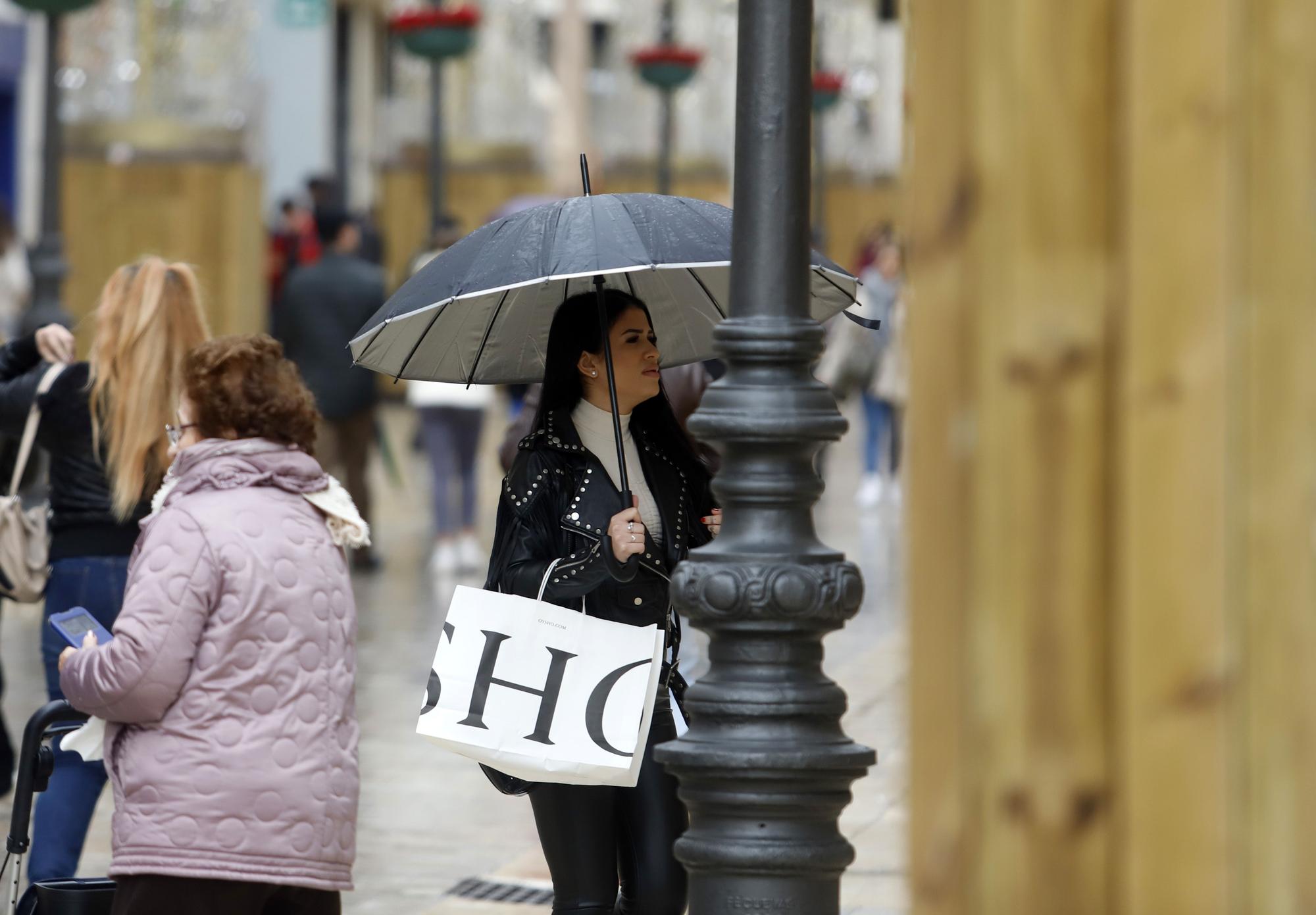 Gente pasea bajo la lluvia por el Centro de Málaga.