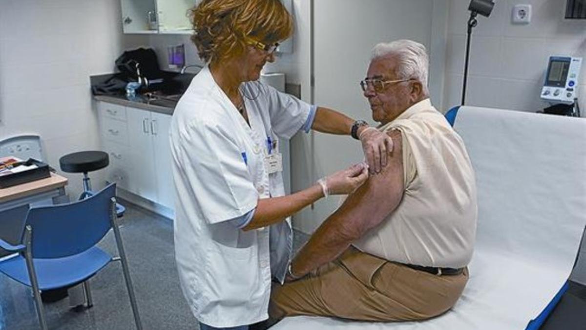 Un vecino del distrito barcelonés de Les Corts recibe la vacuna de la gripe en su CAP, el pasado octubre.