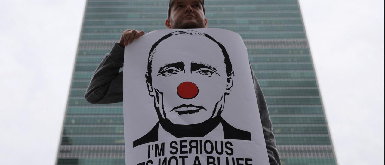 Un  nombre muestra una pancarta de protesta contra Vladimir Putin, en Nueva York