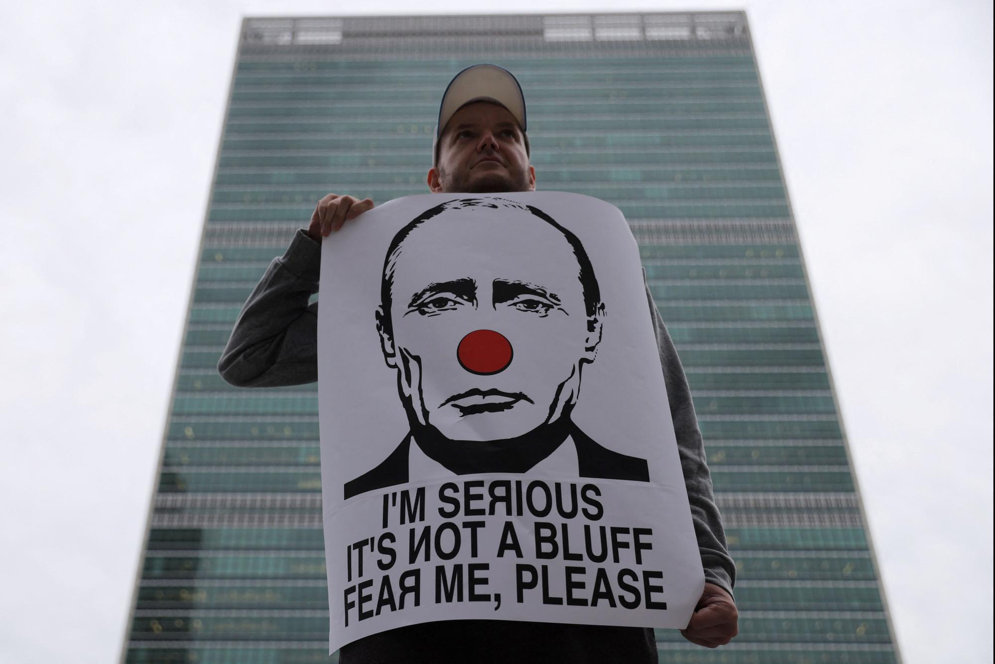 Un  nombre muestra una pancarta de protesta contra Vladimir Putin, en Nueva York