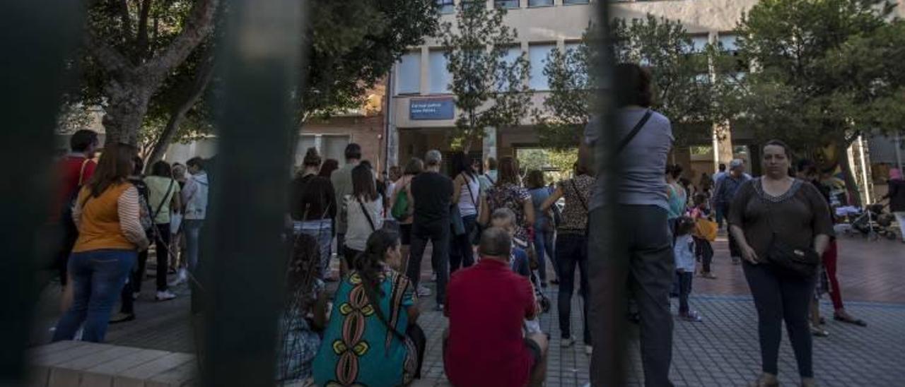 Padres y madres esperando la salida de los niños de un colegio público de Elche.