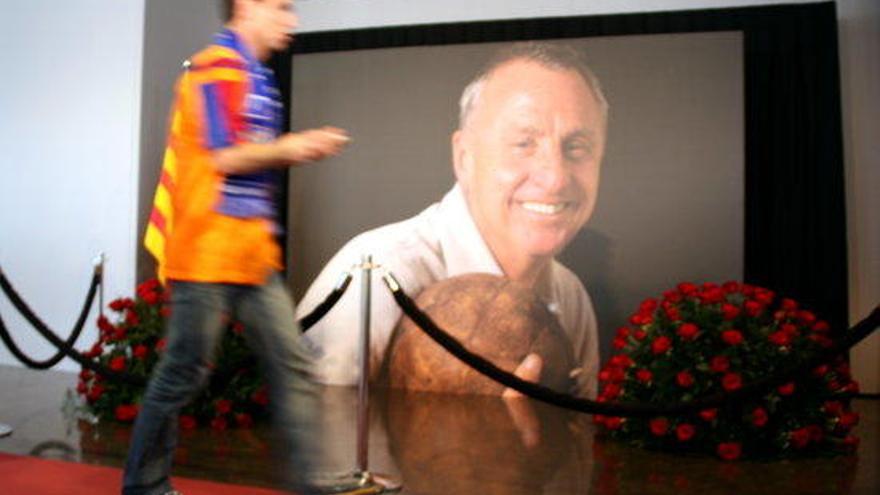 Un aficionat passa davant una foto de Cruyff.