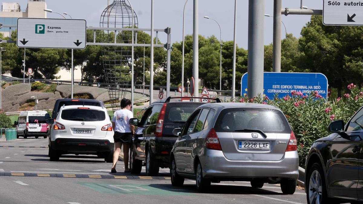 Una conductora sale del vehículo en el embotellamiento de acceso al parking exprés del aeropuerto