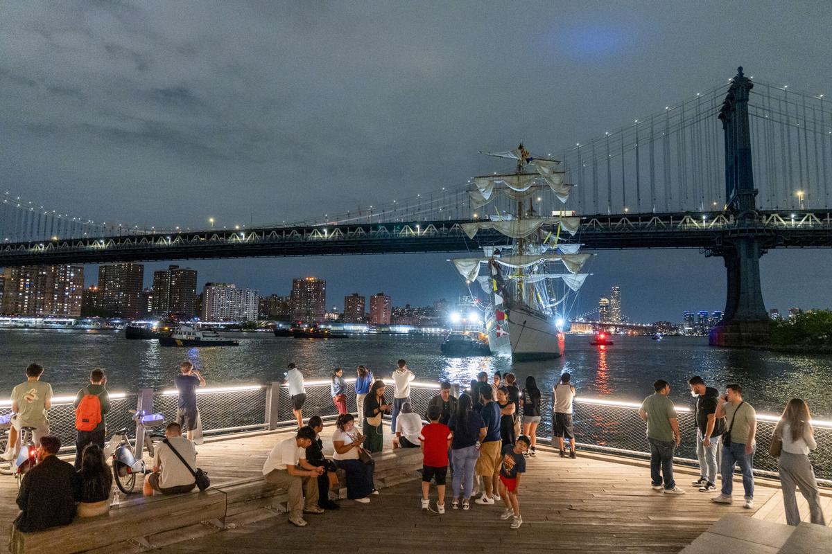 Personas observan el buque escuela mexicano Cuauhtémoc junto al puente de Brooklyn este sábado, en Nueva York (EE.UU.). EFE/ Angel Colmenares