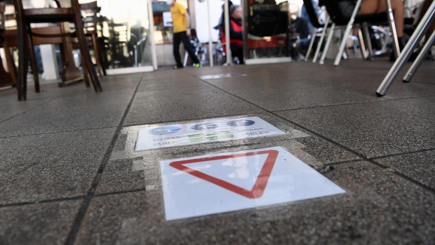 Indicaciones de seguridad en el suelo de una terraza en A Coruña.