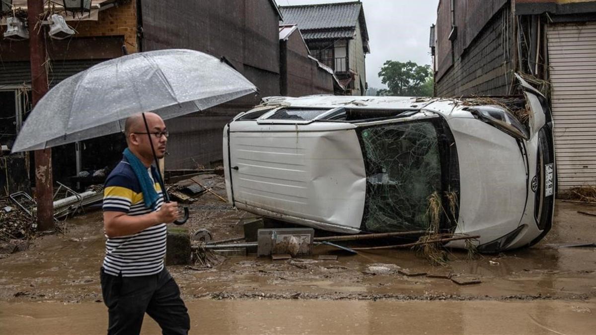 Un hombre anda frente a los destrozos causados por las lluvias en Japón.