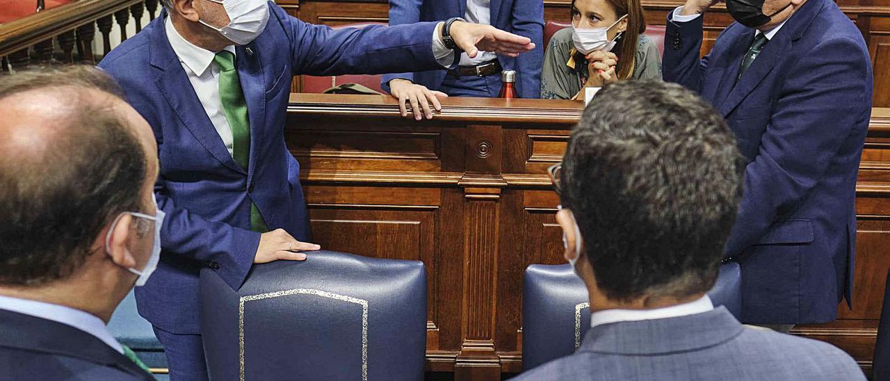 Ángel Víctor Torres hablando ayer en el pleno del Parlamento canario con otros diputados. | | CARSTEN W. LAURITSEN