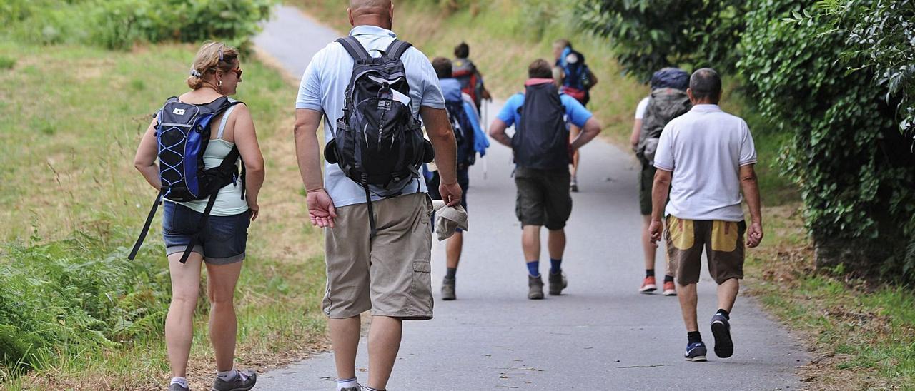 Peregrinos recorriendo el Camino Portugués a Santiago, a su paso por Valga, en una imagen de archivo. | // IÑAKI ABELLA