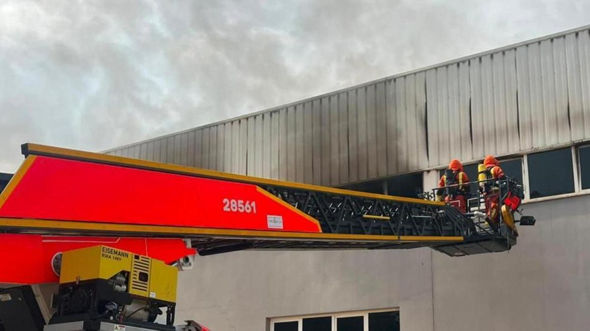Los bomberos trabajan en la extinción del incendio en la nave.