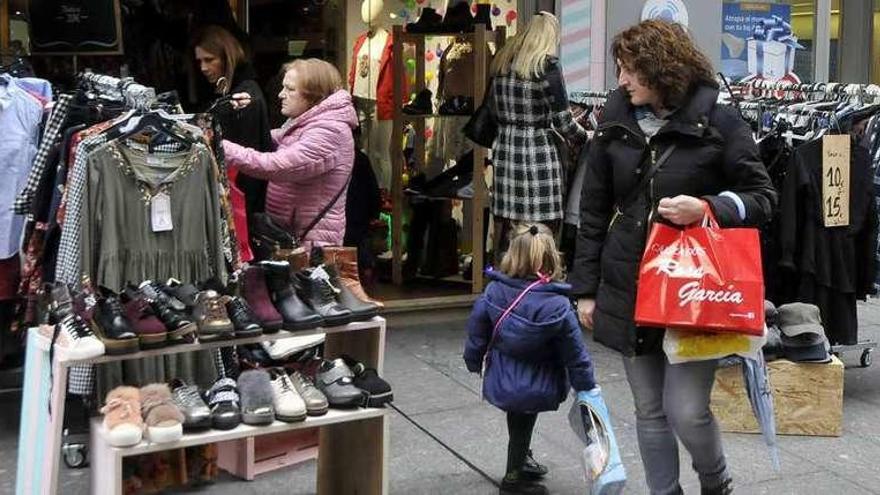 Clientes en uno de los establecimientos de la calle La Vega que participan en la Feria del stock de Mieres.