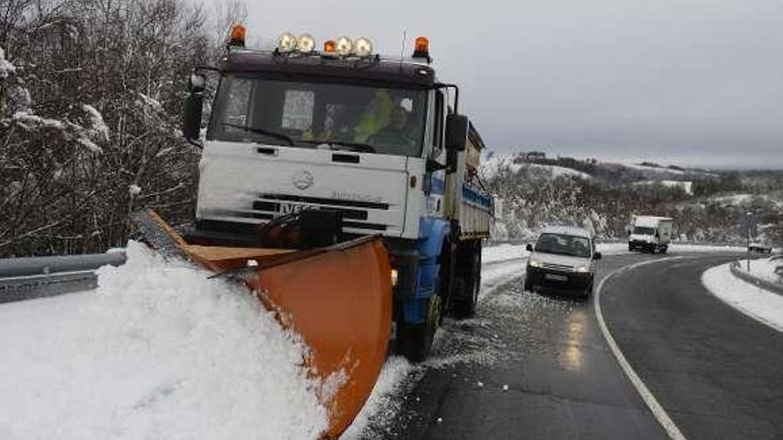 Arriba, un vecino retira con una pala un manto de nieve junto a su casa, en el alto do Rodicio, en Maceda. Abajo, una quitanieves limpia el arcén de la OU-536,  en Montederramo.  // Brais Lorenzo