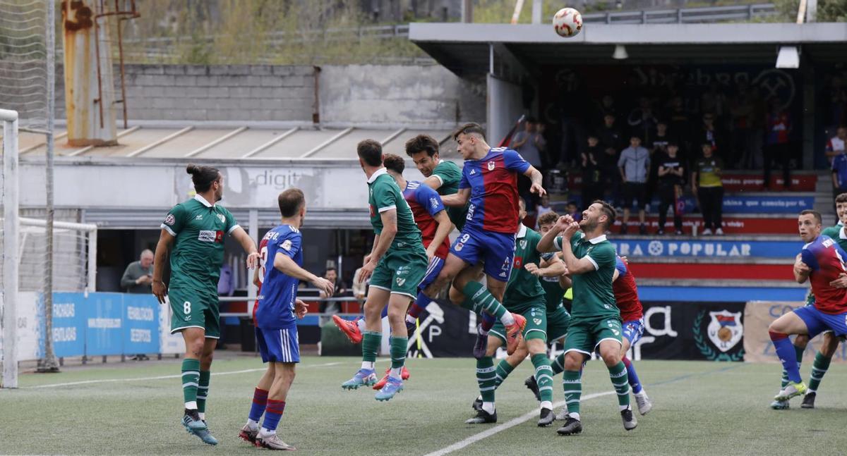 Jugadores del Coruxo intentan evitar el remate de dos jugadores del Langreo durante el partido de ayer. | Fernando Rodríguez