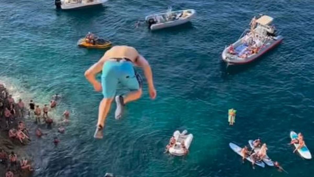 Uno de los jóvenes saltando desde la costa de la Torre d'en Rovira