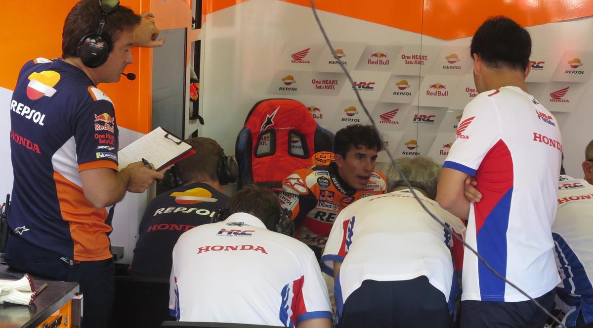 Marc Márquez conversa, tras una de sus paradas en el boxe del equipo Repsol Honda, con sus técnicos, entre los que está el jefe supremo técnico de Honda, Shinya Wakabayashi.