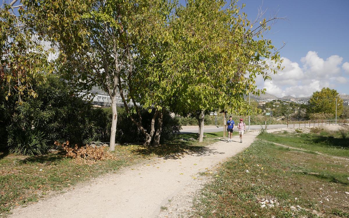Dos ciudadanos pasean por el sendero fluvial del rio Algar.