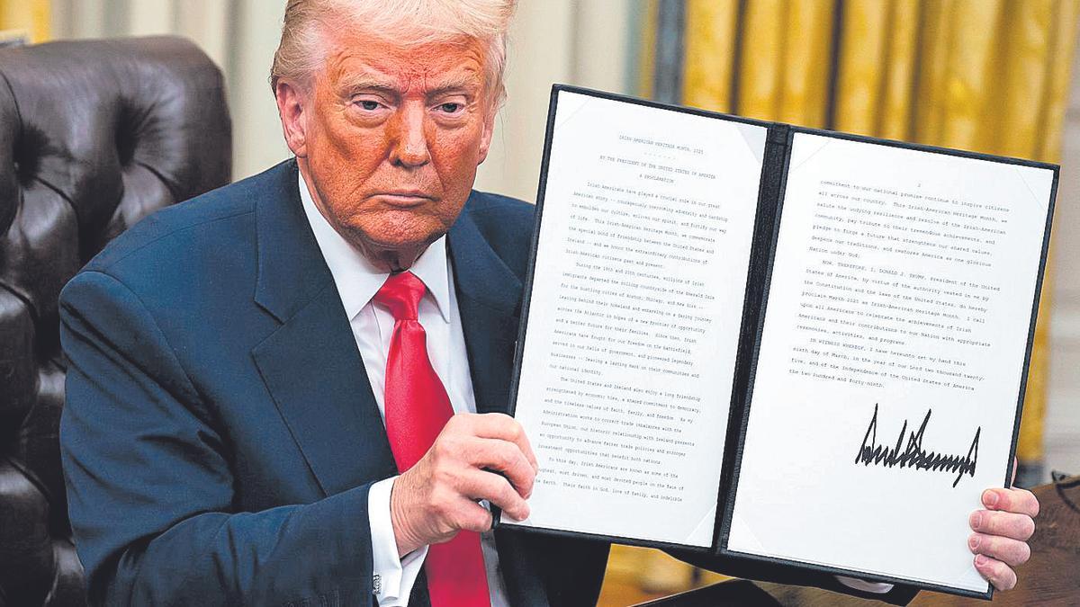 Donald Trump muestra la orden ejecutiva que pausa la subida de aranceles a México y Canadá.