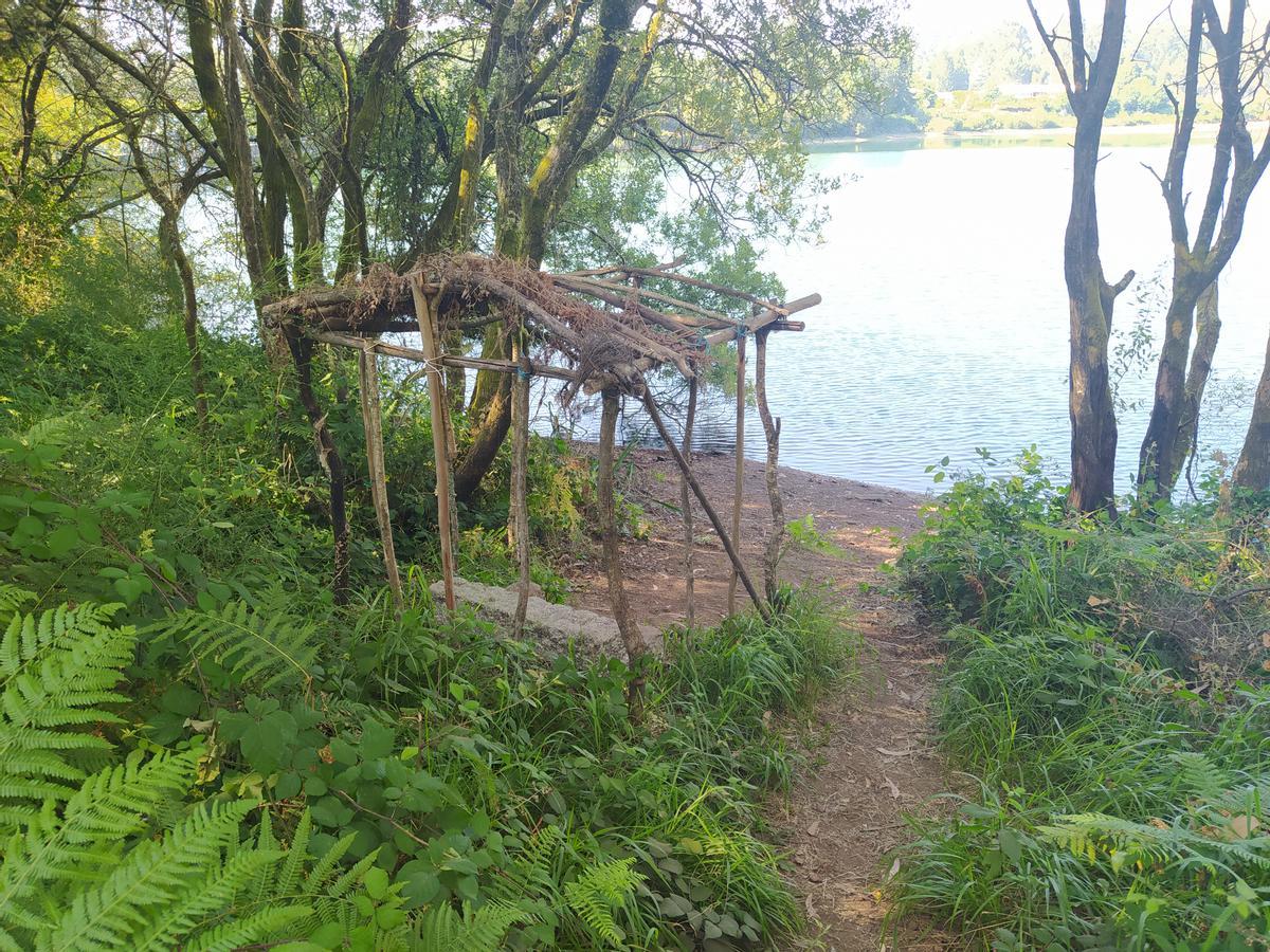 Una choza al pie del embalse de Zamáns.