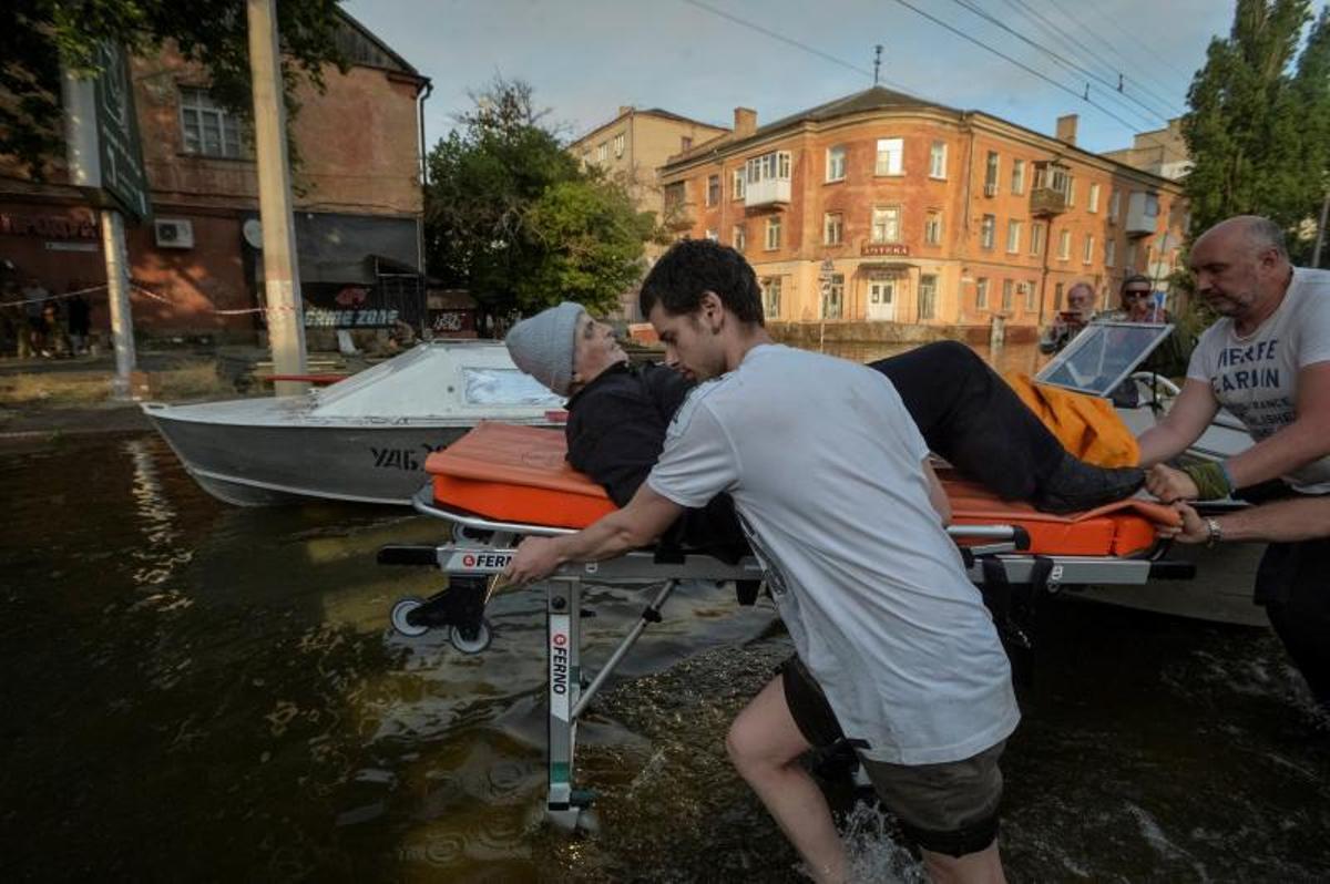 Los voluntarios entregan alimentos a los residentes locales en un área inundada, en medio del ataque de Rusia a Ucrania, en Kherson